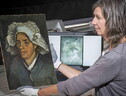 Lesley Stevenson, senior painting conservator delle National Galleries of Scotland mostra il dipinto Testa di Contadina. Sul retro è apparso l'autoritratto di Van Gogh (ANSA)