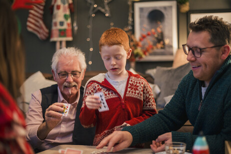 Tre generazioni riunite per i giochi di Natale foto iStock.