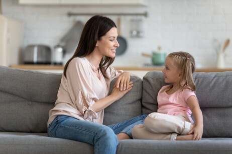 Una mamma parla sul divano con la figlia foto iStock.