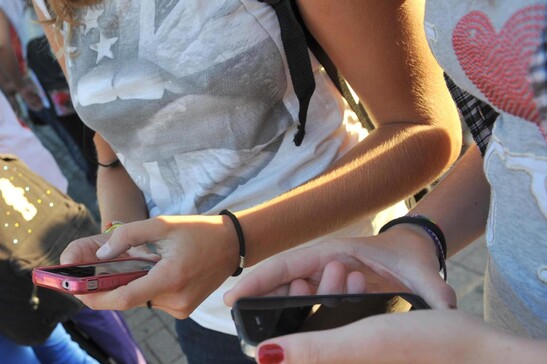 La foto d'archivio di adolescenti che consultano i loro smartphone.