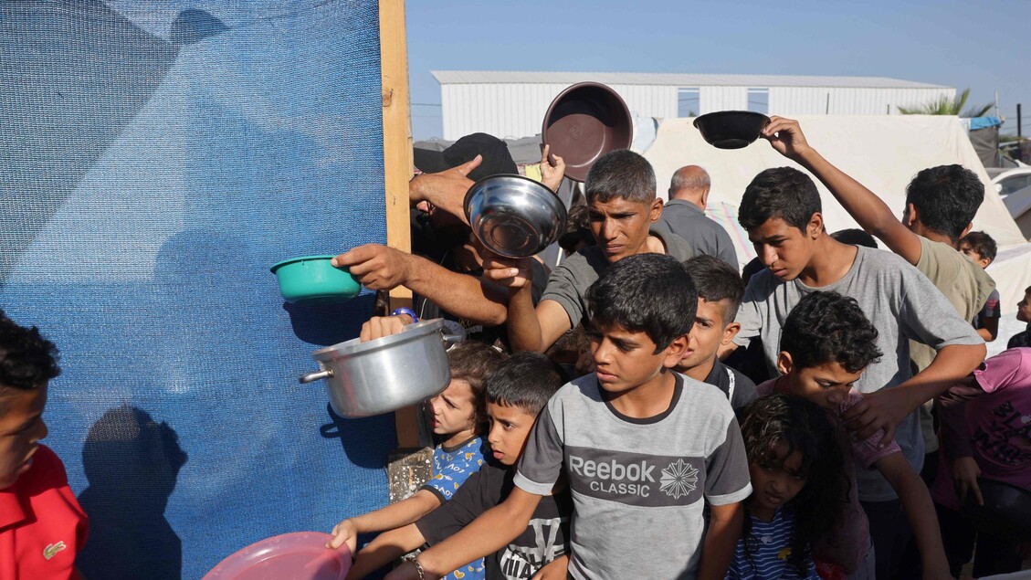Guerra Medioriente - Rifugiati palestinesi attendono il pasto a Khan Yunis © ANSA/AFP