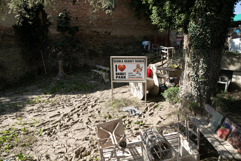 Un 'area per i giochi dei bambini ricoperta del fango dell 'alluvione di un mese fa, Faenza (Ravenna) - RIPRODUZIONE RISERVATA