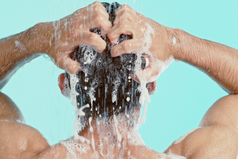 Un uomo sotto la doccia si lava i capelli foto iStock. - RIPRODUZIONE RISERVATA